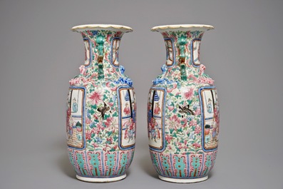 A pair of Chinese famille rose vases with figures in an interior, 19th C.