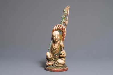 A large polychrome Chinese ivory group of a sage with a mythical beast, 19th C.