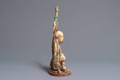 A large polychrome Chinese ivory group of a sage with a mythical beast, 19th C.