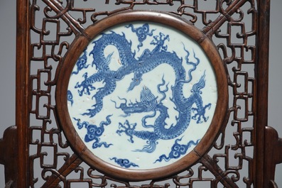 A Chinese carved wood table screen with a blue and white dragon medallion, Ming and 19th C.
