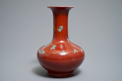 A Chinese oxblood-glazed bottle vase with an overglaze design of a qilin and a bird, 19th C.