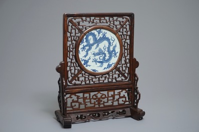 A Chinese carved wood table screen with a blue and white dragon medallion, Ming and 19th C.