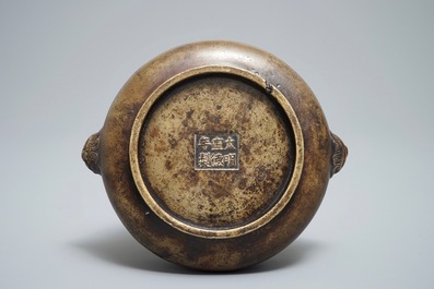 Een Chinese bronzen wierookbrander op houten voet, Xuande merk, 18e eeuw