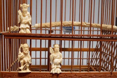 Een Chinese houten vogelkooi met ivoren en porseleinen ornamenten, 19/20e eeuw