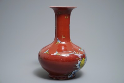 A Chinese oxblood-glazed bottle vase with an overglaze design of a qilin and a bird, 19th C.