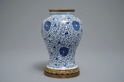 Een Chinese blauwwitte vaas met pioenslingers met montuur in verguld brons, Kangxi