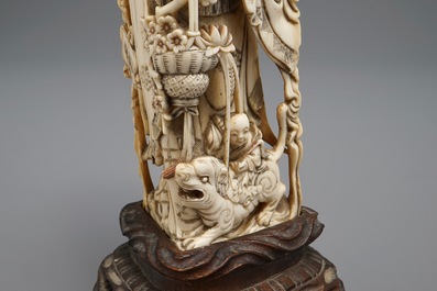 A Chinese carved ivory figure of an immortal with mythical beasts, 19th C.