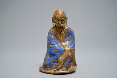 A Chinese champlev&eacute; enamel and gilt copper model of a Luohan, Qianlong