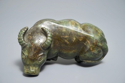 A Chinese spinach green jade model of an ox on wooden stand, 19/20th C.
