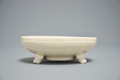 A Chinese monochrome cream-glazed vase and a tripod censer, Ming