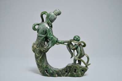A Chinese spinach green jade group of Guanyin with a child, 19th C.
