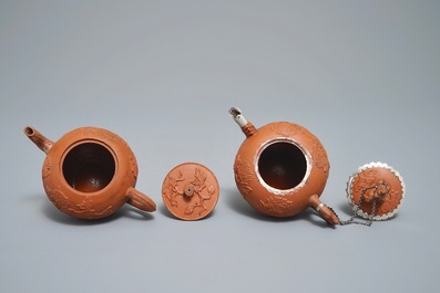 Twee Chinese Yixing steengoed theepotten met reli&euml;fdecor, Kangxi