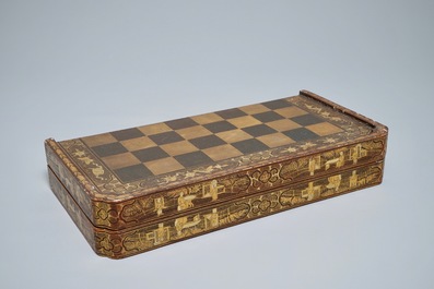 A Chinese lacquered chess and backgammon board with ivory chessmen, 19th C.