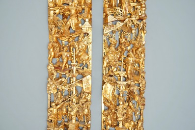 A pair of Chinese carved, lacquered and gilt wood panels with figurative designs, 19th C.