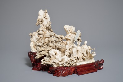 A Chinese ivory group of figures in a landscape on carved wooden base, 1st half 20th C.