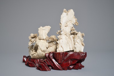 A Chinese ivory group of figures in a landscape on carved wooden base, 1st half 20th C.