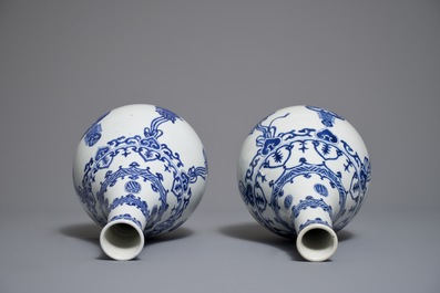 A pair of Chinese blue and white bottle vases with ribbons and precious objects, Kangxi