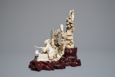 A Chinese ivory group of figures in a landscape on carved wooden base, 1st half 20th C.