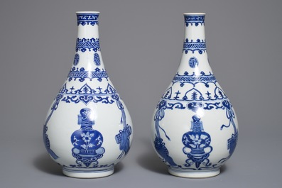 A pair of Chinese blue and white bottle vases with ribbons and precious objects, Kangxi