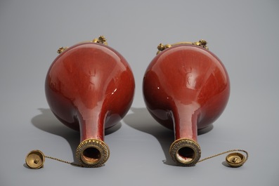 Une paire de vases en porcelaine de Chine sang de boeuf aux montures en bronze dor&eacute;, 19&egrave;me