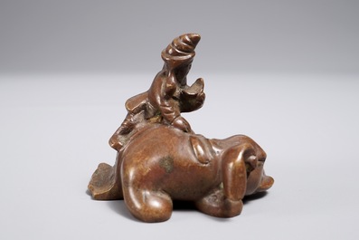 Een Chinees bronzen scroll- of papiergewicht in de vorm van een olifant met berijder, 19/20e eeuw