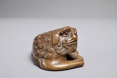 Een Chinees bronzen scroll- of papiergewicht in de vorm van een Boeddhistische leeuw of Shishi, 17/18e eeuw
