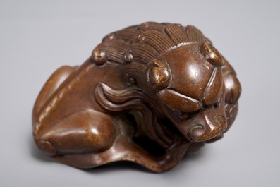 Een Chinees bronzen scroll- of papiergewicht in de vorm van een Boeddhistische leeuw of Shishi met bal, 17/18e eeuw