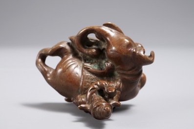 Een Chinees bronzen scroll- of papiergewicht in de vorm van een olifant met berijder, 19/20e eeuw