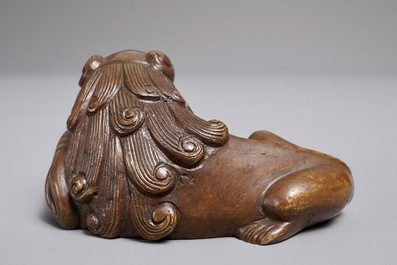 A Chinese bronze scroll or paper weight shaped as a Buddhist lion or Shishi with a ball, 17/18th C.