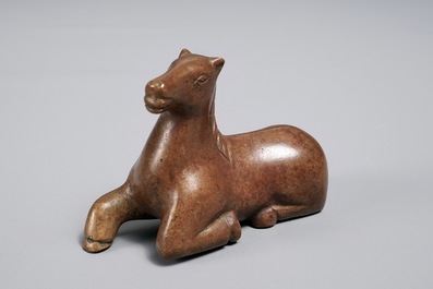 Een Chinees bronzen scroll- of papiergewicht in de vorm van een liggend paard, 19/20e eeuw