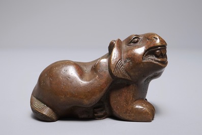 A Chinese bronze scroll or paper weight shaped as a mythical beast, 18/19th C.