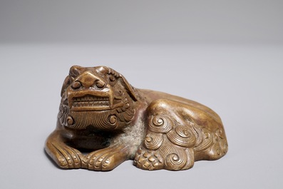 Een Chinees bronzen scroll- of papiergewicht in de vorm van een Boeddhistische leeuw of Shishi, 17/18e eeuw