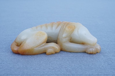 A Chinese carved russet jade model of a reclining dog, 19/20th C.