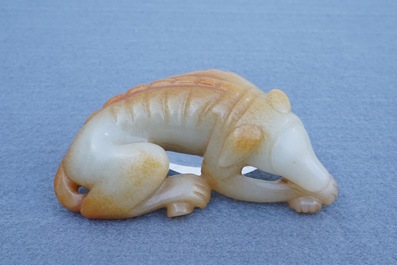 A Chinese carved russet jade model of a reclining dog, 19/20th C.