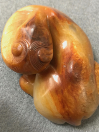 A Chinese carved russet jade model of a reclining horse, 19/20th C.