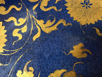 Een Chinese poederblauwe en vergulde schotel met lotusslingers, Kangxi