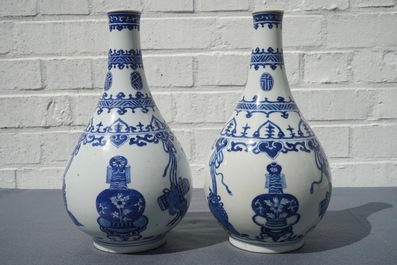 Een paar Chinese blauwwitte flesvormige vazen met kostbaarheden en franjes, Kangxi