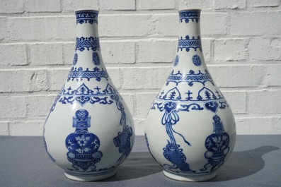 A pair of Chinese blue and white bottle vases with ribbons and precious objects, Kangxi