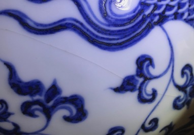 Un vase de forme bouteille en porcelaine de Chine bleu et blanc aux dragons, 19/20&egrave;me