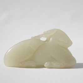 A Chinese jade carving of a ram on wooden base, 19th C.