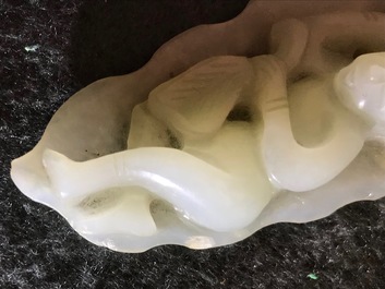 A Chinese celadon jade model of a reclining lady on lotus leaf, Qing