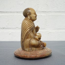 Een Chinese Shoushan zeepstenen figuur op basement met inscriptie, 19/20e eeuw