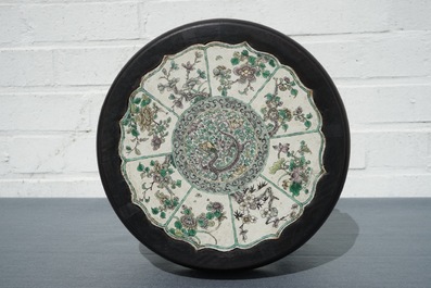 Une plaque en forme de lotus en biscuit &eacute;maill&eacute;e verte dans un socle en bois sculpt&eacute;, Kangxi