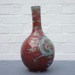 A Chinese oxblood-glazed bottle vase with overglaze design of a dragon and a carp, 19th C.