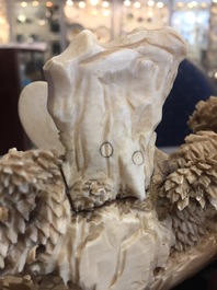 Un groupe en ivoire sculpt&eacute; de figures dans un paysage sur socle en bois sculpt&eacute;, Chine, 1&egrave;re moiti&eacute; du 20&egrave;me