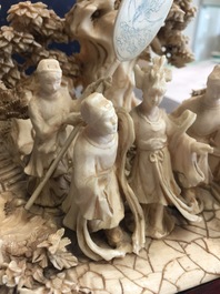 A Chinese ivory group of figures in a landscape on carved wooden base, 1st half 20th C.