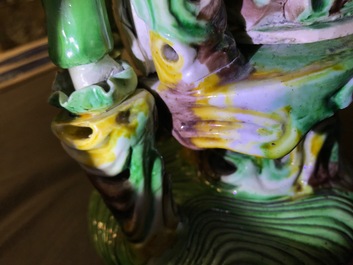 A Chinese verte biscuit group of Guanyin on a lotus throne, 18th C.