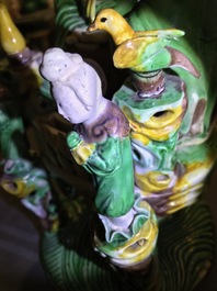 A Chinese verte biscuit group of Guanyin on a lotus throne, 18th C.