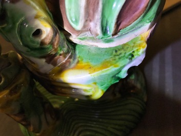 A Chinese verte biscuit group of Guanyin on a lotus throne, 18th C.