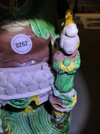 A Chinese verte biscuit group of Guanyin on a lotus throne, 18th C.